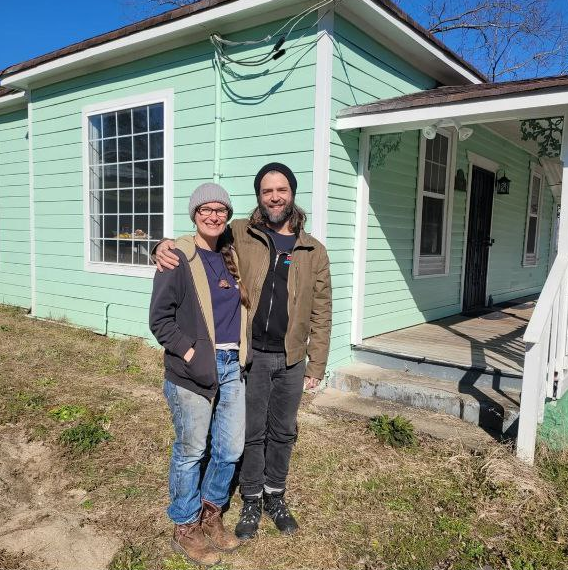 Russell and Alexis in front of their first house.